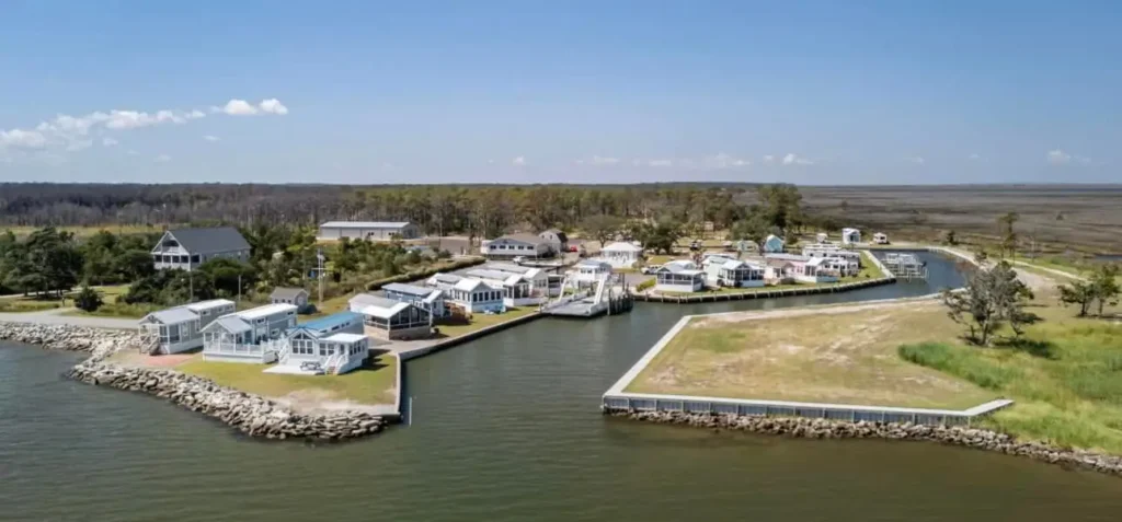 Aerial photo of a waterfront resort community with white cottages, boat docks, canal, bulkhead seawalls, and